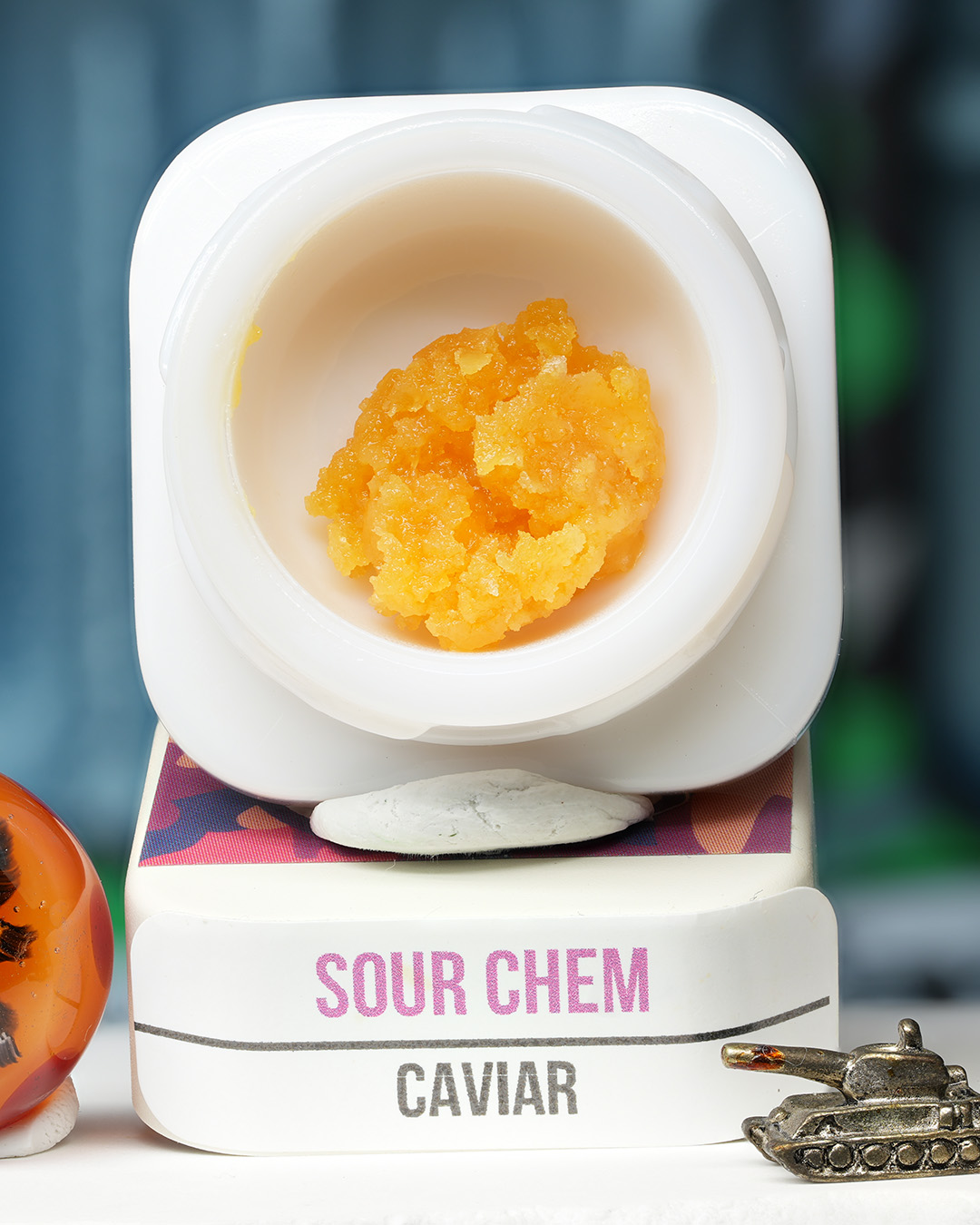 Sour Chem BHO caviar jar with bright orange-gold textured concentrate in Dank Tank studio photography
